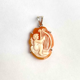 Carved shell cameo pendant depicting a cherub seated with a lyre. The cameo is set in a sterling