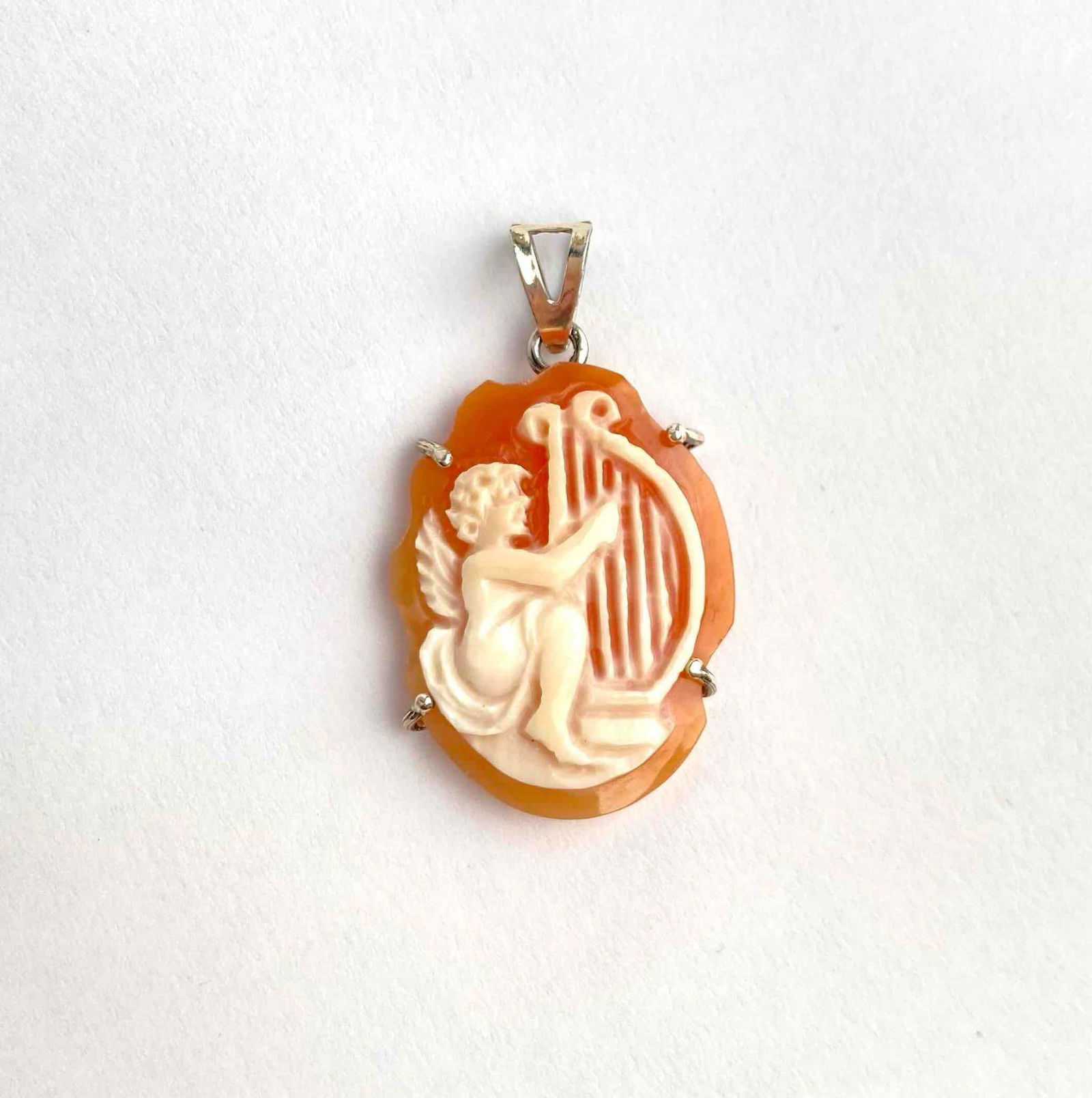 Carved shell cameo pendant depicting a cherub seated with a lyre. The cameo is set in a sterling (1 of 5)