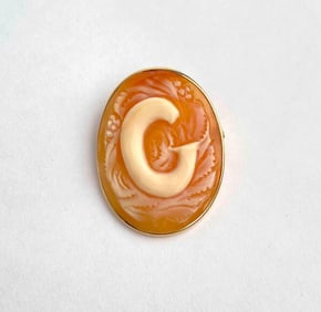 Italian shell cameo pendant brooch featuring a hand carved letter G in raised relief, framed by