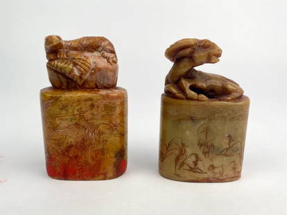 Pair of Hand Carved Chinese Soapstone Animal Seal Chops with Landscape Etching: Pair of vintage hand carved Chinese soapstone seal chops, each featuring a finely sculpted animal finial, one depicting a resting ram and the other a tiger resting on a rock. The cylindrical bases