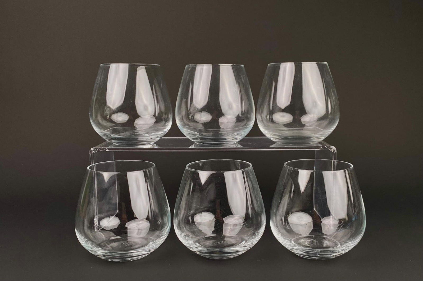 Set of Six Schott Zwiesel Stemless Wine Glasses: Set of six Schott Zwiesel stemless wine glasses. Each glass features the Schott Zwiesel mark inscribed on the base. Glasses are in good condition with some surface scratches consistent with age and us