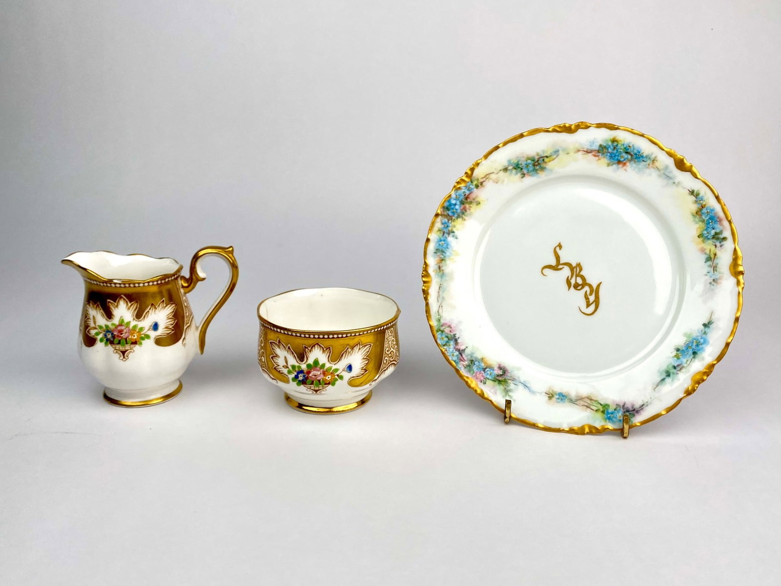 Royal Albert Bone China Creamer and Sugar Bowl with RC Versailles Plate: Three piece lot of fine porcelain including a matching Royal Albert bone China creamier and open sugar bowl, along with a hand decorated RC Versailles plate. The Royal Albert pieces feature gold gilt