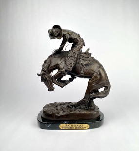 Frederic Remington Bronze Sculpture Rattlesnake on Marble Base: A bronze sculpture titled Rattlesnake by Frederic Remington, mounted on a black marble base. The plaque on the base features the title and artists name. Capturing an intense moment between a cowboy an