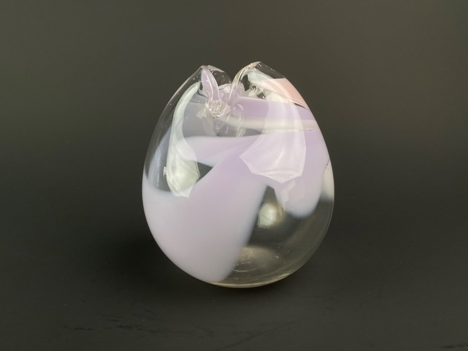 Studio Art Glass Vase with Pink and Lavender Swirls: Hand blown contemporary studio art glass vase featuring soft swirls of lavender, pink and white within a clear glass body. The organic, asymmetrical form curves inward at the top, creating a naturalis