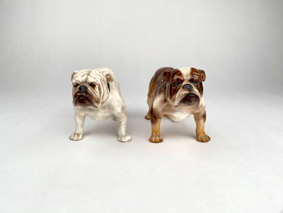 Pair of Royal Doulton Porcelain Bulldog Figurines: Porcelain bulldog figurines by Royal Copenhagen, featuring detailed hand painted designs in white and brown with black collars. Both pieces bear the Royal Copenhagen hallmark on the underside along wi