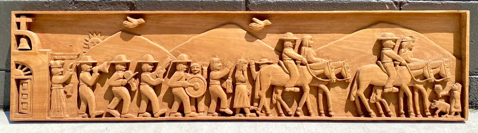 Large Mexican Folk Art Carved Wooden Relief by Angel Valdez, 1978: Carved wooden relief signed and dated by Angel Valdez, 1978. Features a detailed depiction of a parade or procession with figures on foot and horseback set against a mountainous backdrop. Crafted from