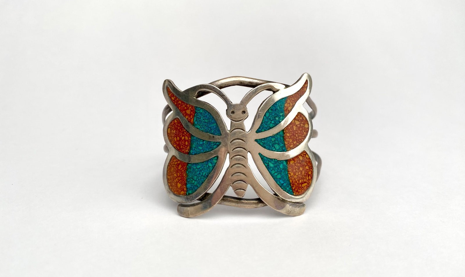 Butterfly Sterling Silver Cuff Bracelet With Inlaid Turquoise and Coral: Mexican sterling silver cuff bracelet crafted in a butterfly design. Features vibrant inlaid turquoise and coral details. The bracelet is stamped with makers marks on the interior as pictured. Please 