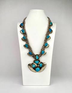 Vintage Mexican Sterling Silver and Turquoise Squash Blossom: Mexican sterling silver squash blossom necklace featuring multiple turquoise stones set in detailed silver bezels. The piece includes a central pendant with additional turquoise stones and scalloped