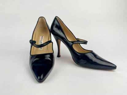 Manolo Blahnik Black Patent Leather Mary Jane Heels (Size 40): Pair of black patent leather Mary Jane heels by Manolo Blahnik. These pumps feature a pointed toe, high stiletto heel, and a classic single-strap Mary Jane design with a covered button closure. The sh