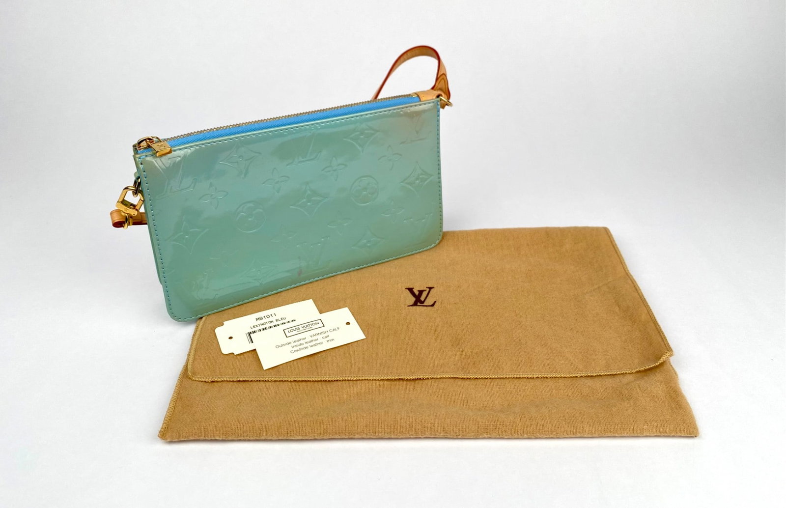Louis Vuitton Lexington Bleu Vernis Leather Wristlet with Dust Bag: Louis Vuitton Lexington Bleu wristlet crafted from Vernis leather with embossed monogram pattern, featuring a blue zipper closure, gold tone hardware, and cowhide leather trim. Includes detachable wri