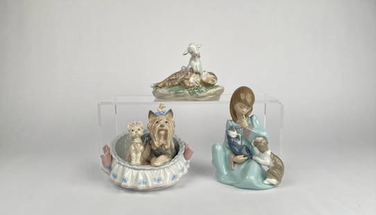Set of Three Lladr Porcelain Figurines: Three LladrÃ³ porcelain figurines, including: | 1. Lamb and Leopard (model 6926), depicting a lamb resting on a spotted leopard with floral detailing on the base. | 2. Girl with Dog and Cat (model 5