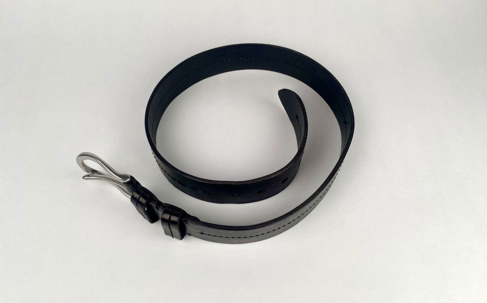 Lauren Ralph Lauren Black Leather Belt with Silver Tone Buckle: Lauren Ralph Lauren black leather belt featuring a silver tone metal buckle. Constructed from genuine leather, as marked on the inner side. The belt includes embossed branding and functional adjustmen