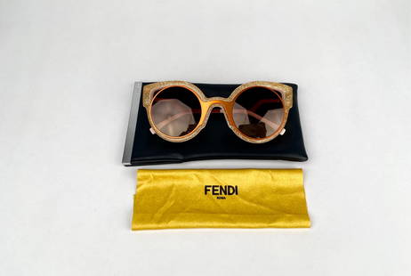 Fendi FF0137/S Glitter Sunglasses with Fendi Case: Fendi round frame sunglasses featuring gold glitter acetate frames and gradient orange tinted lenses. The temples are pink with a sharp geometric design and gold tone Fendi branding. Includes the orig