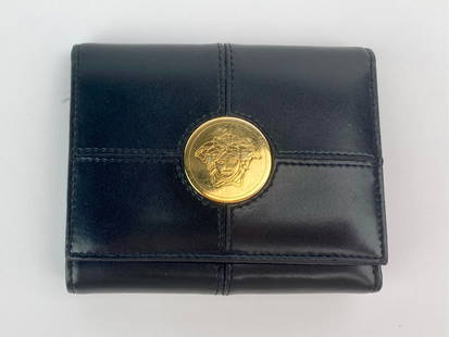 Gianni Versace Black Leather Medusa Wallet: Gianni Versace tri-fold wallet crafted in black leather and made in Italy. The wallet features a large round gold-tone Medusa medallion on the front flap, stitched panel construction, and gold-tone sn