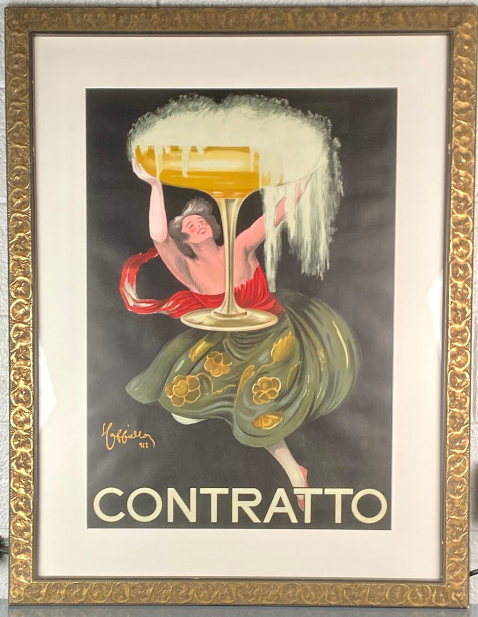 Framed Poster of Contratto by Leonetto Cappiello, 1922: Framed reproduction poster of Contratto by Leonetto Cappiello, originally created in 1922. The lithograph-style image features a woman in festive dress lifting an oversized coupe glass brimming with f