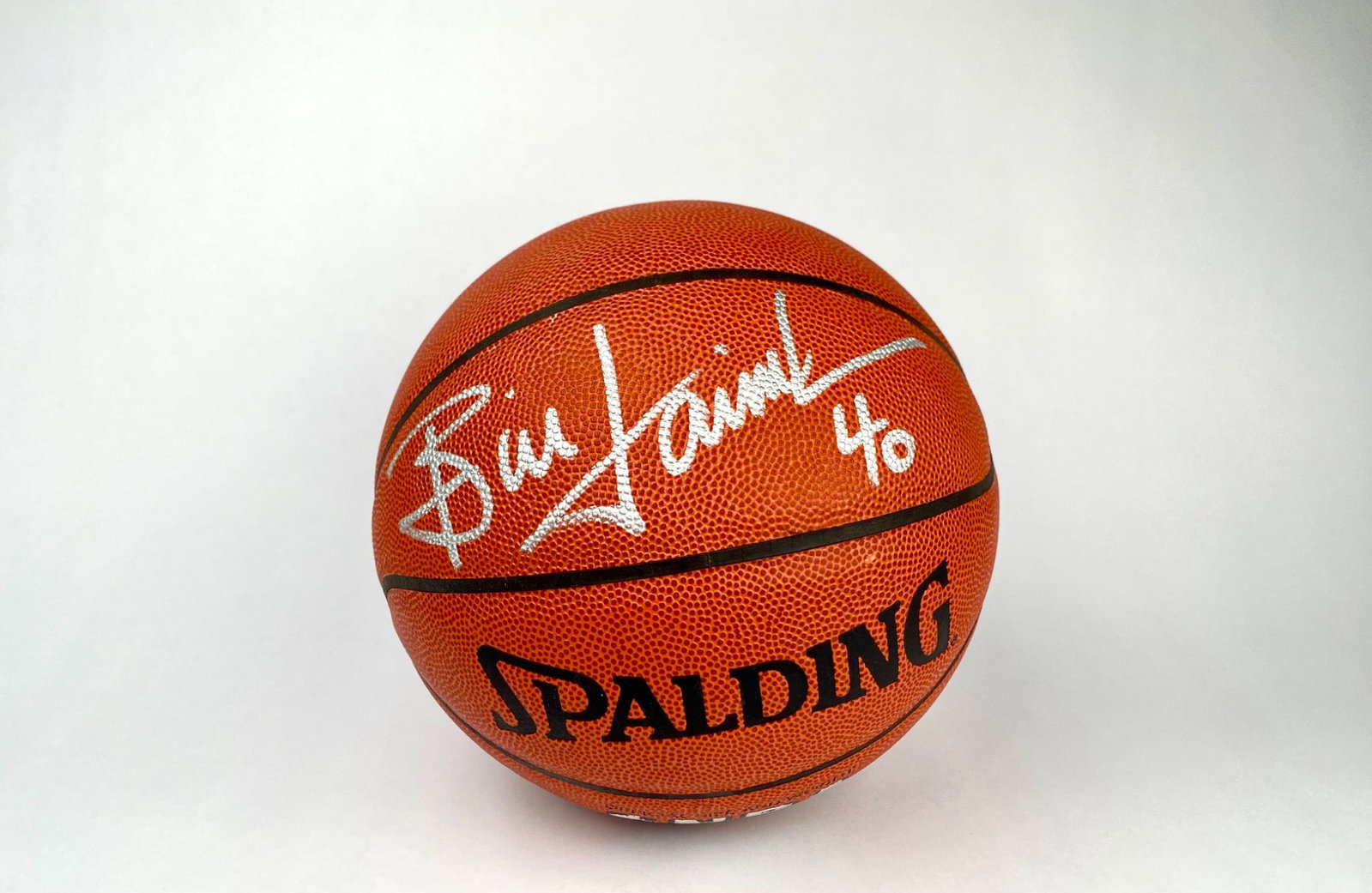 Spalding NBA Basketball Signed by Bill Laimbeer: A Spalding NBA indoor/outdoor basketball signed in silver ink by Bill Laimbeer and the number ’40’ inscribed. Made from genuine leather with official size and weight markings. Features NBA endorse