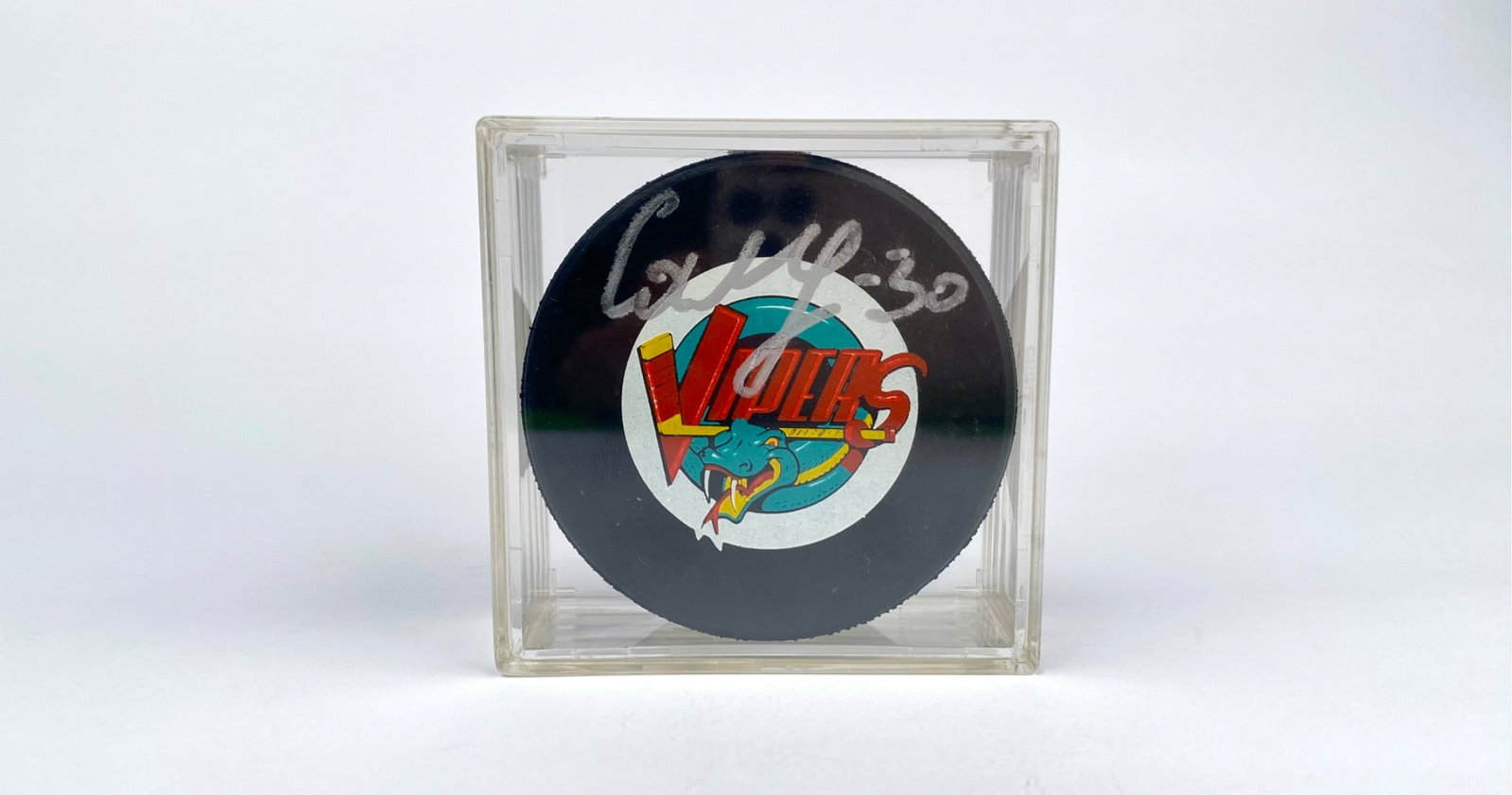 Signed Maxim Mikhailovsky Vipers Hockey Puck in Display Case: Official licensed Vipers hockey puck, signed by Maxim Mikhailovsky. Features the Vipers logo on one side and International Hockey League (IHL) branding on the reverse. Comes encased in a clear display