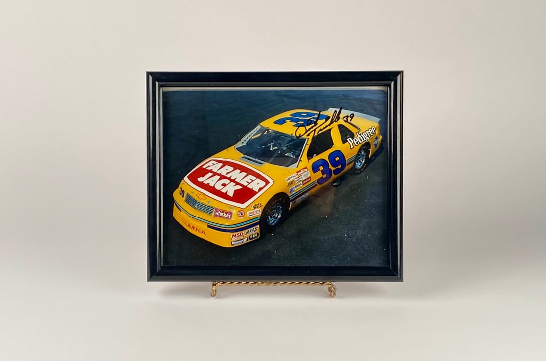 Autographed Quentin Townsend #39 Farmer Jack NASCAR Photo: Framed photograph of the No. 39 yellow race car with visible sponsor logos, bearing a black signature marked “39” on the car’s roof area. Photo is autographed by Quentin Townsend. Photograph