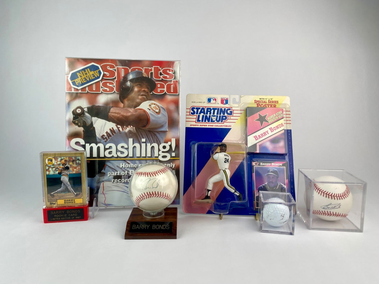 Barry Bonds Memorabilia Collection Featuring Signed Balls, Signed Rookie Card and Collectibles: Barry Bonds collection featuring both autographed and vintage memorabilia. Set includes two signed baseballs, each on Rawlings Official Nation League balls, one displayed on a wooden stand and one in