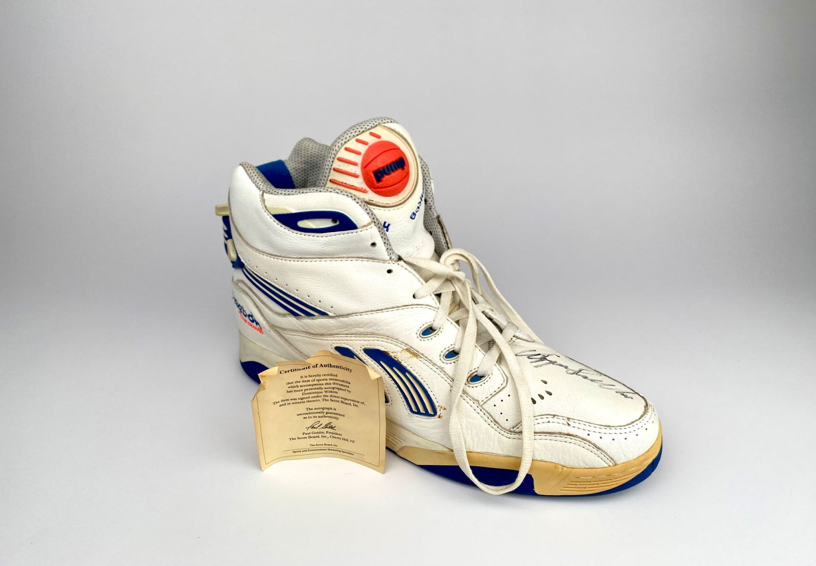 Reebok Pump Basketball Shoe Signed by Dominique Wilkins With COA: A Reebok Pump basketball shoe featuring a hand-signed autograph by Dominique Wilkins. Includes a Certificate of Authenticity issued by The Score Board Inc., verifying the signature's authenticity. The