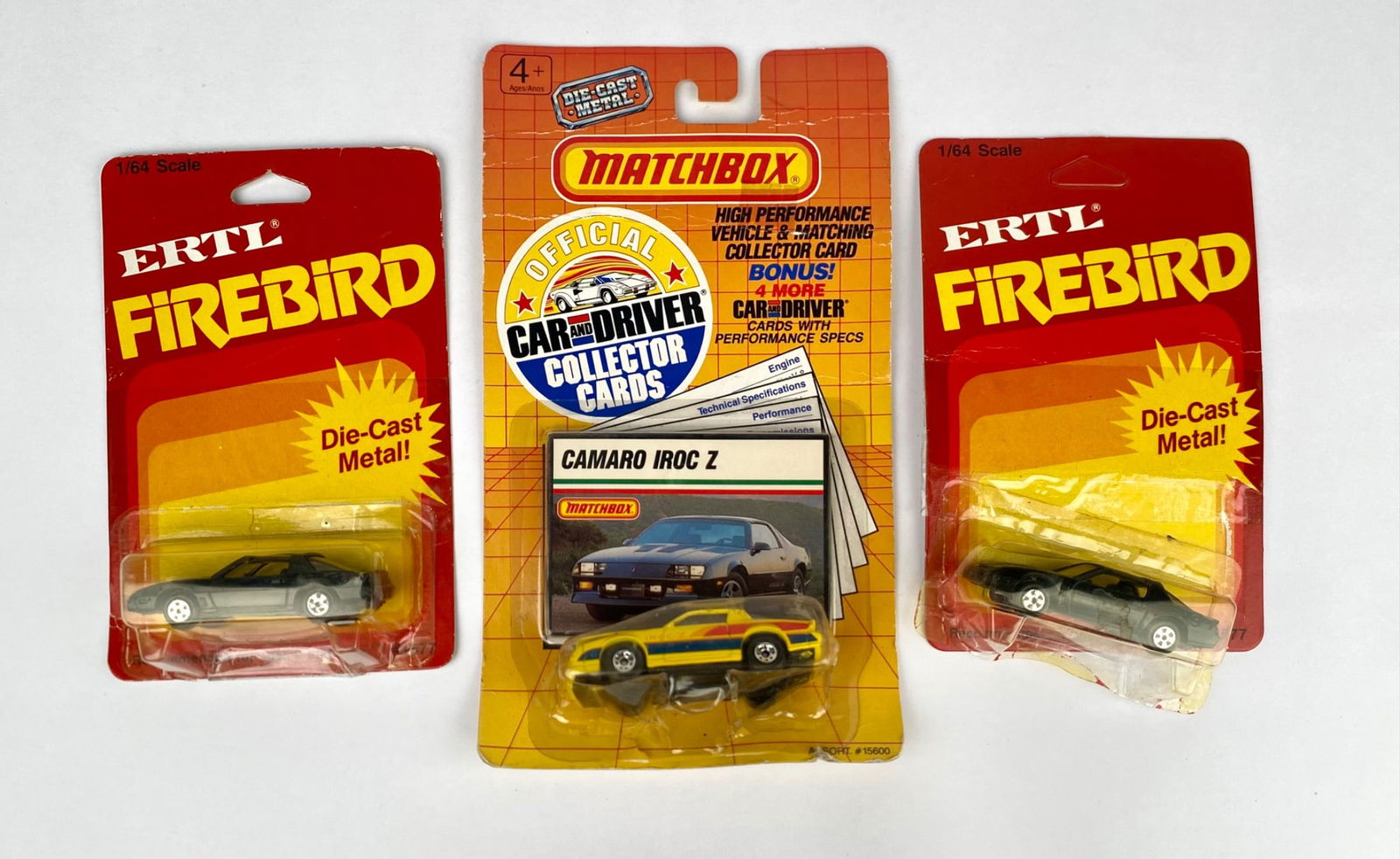3 Die-Cast Model Cars: 1 Matchbox Camaro IROC Z and 2 ERTL Firebird: Three die-cast metal model cars includes one Matchbox Camaro IROC Z (official Car and Driver collector card included) and two ERTL Firebird cars. The Matchbox model features original packaging with bo