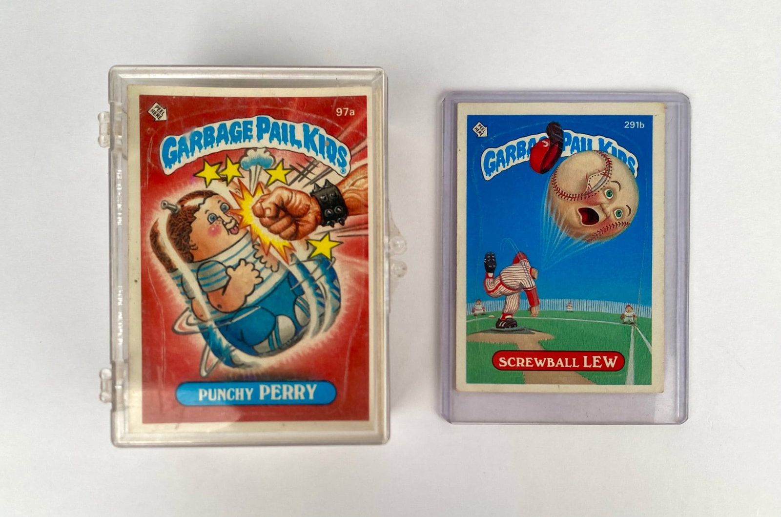 Garbage Pail Kids Trading Card Assortment: Garbage Pail Kids trading cards, featuring popular characters including "Punchy Perry" (#9a) and "Screwball Lew" (#291b), both individually sleeved. The collection includes additional loose cards, dep
