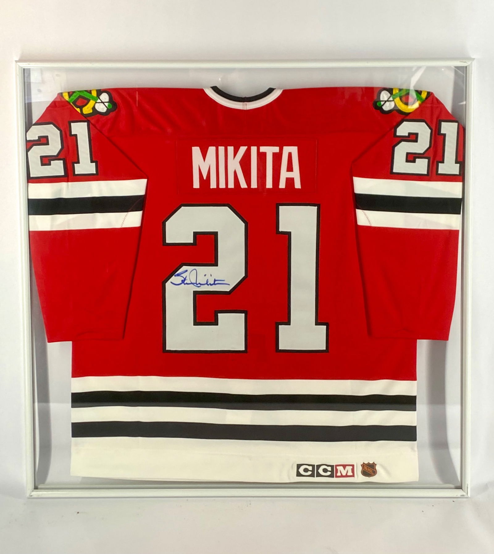 Stan Mikita Signed Chicago Blackhawks Authentic CCM Framed Jersey: Authentic CCM Chicago Blackhawks home jersey signed by Hall of Famer Stan Mikita. Mikita's autograph is placed on the back numeral in blue marker. The jersey is part of the CCM Center Ice Authentic Co