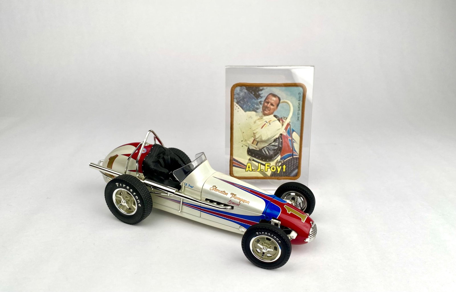1:18 Scale Kurtis Kraft Sprint Car Model with A.J. Foyt Memorabilia with box and COA: 1:18 scale diecast model of a Kurtis Kraft Sprint Car, featuring metallic red, white, and blue livery and detailed sponsor decals with original box and COA. Includes a display card highlighting racer 