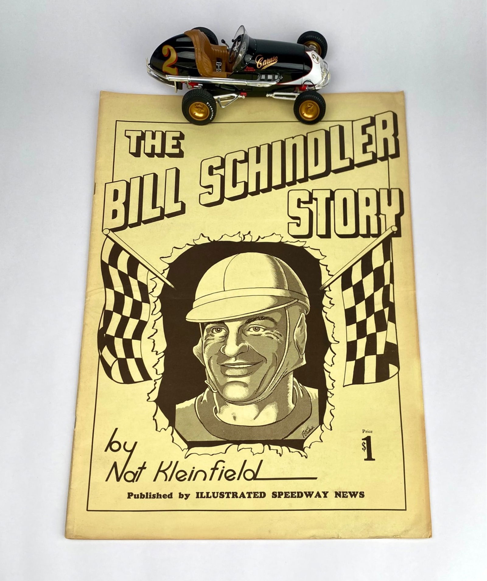 Bill Schindler Story Booklet and Midget Race Car Model with box: A vintage edition of "The Bill Schindler Story" by Nat Kleinfield, published by Illustrated Speedway News, showcasing the life and career of the racing legend with illustrations and period photographs