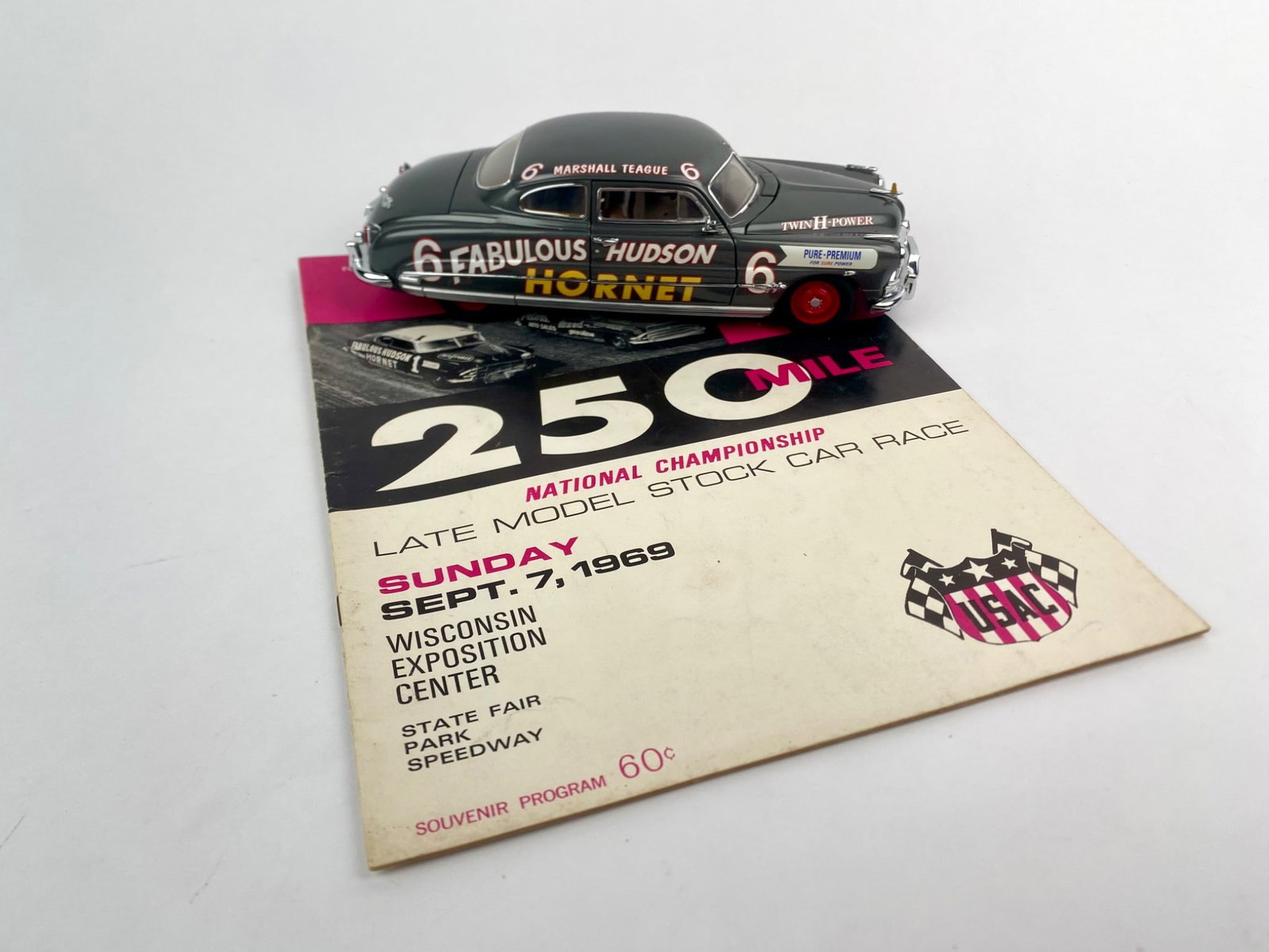 1951 Hudson Hornet #6 Marshall Teague Diecast with 1969 USAC 250 Mile Race Program: Set includes a 1:24 scale diecast model of the 1951 Hudson Hornet #6 driven by Marshall Teague, featuring authentic sponsor decals, opening hood, trunk, and doors, and full engine detail. Accompanying