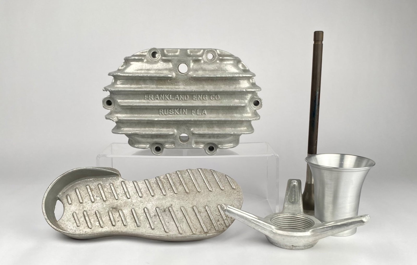 Frankland and Halibrand Aluminum Auto Racing Components: Aluminum auto racing components including items marked Frankland Eng. Co., Ruskin, Fla. and Halibrand. The lot includes a finned aluminum component with the Frankland branding, an aluminum shoe-shaped