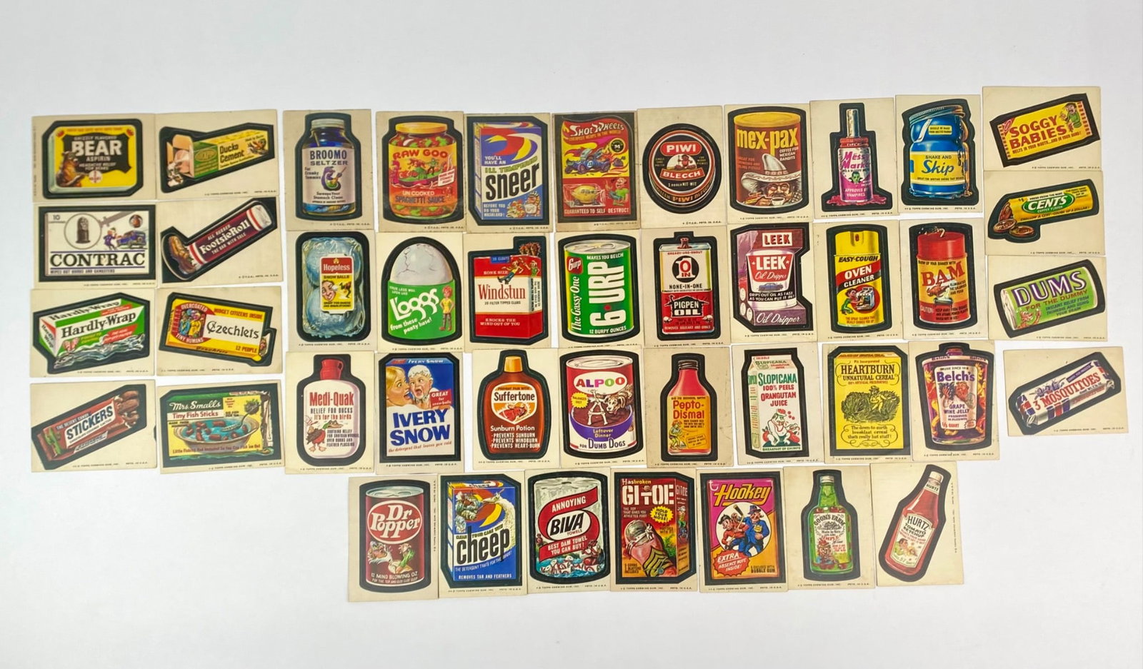 Set of 40 Wacky Packages Reproduction Trading Stickers: Group of reproduction Wacky Packages trading stickers, originally issued by Topps in the 1970s as a parody of popular consumer brands. Each card features satirical artwork and is black-backed, consist