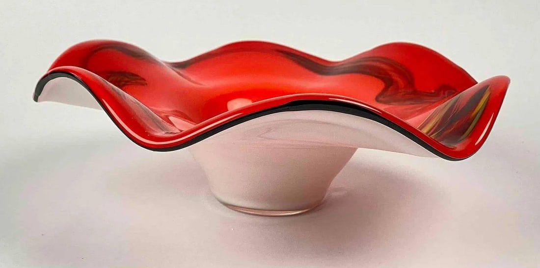 Murano-Style Red and White Art Glass Bowl with Wavy Rim: Handblown art glass bowl featuring a vibrant red interior and a contrasting white underside. The wavy rim and freeform design include a black trim around the edge. The base shows a maker’s label, su