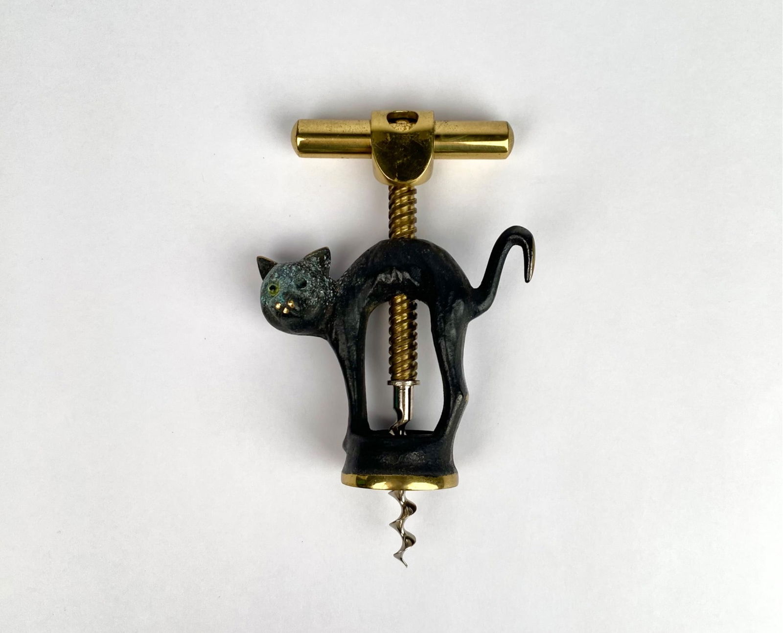 Cat-Shaped Brass and Metal Corkscrew with Turning Handle: Cat-shaped corkscrew made from a combination of brass and dark-toned metal. Featuring a feline design with a turning handle, brass accents, and a spiraled steel screw. Item has wear consistent with ag