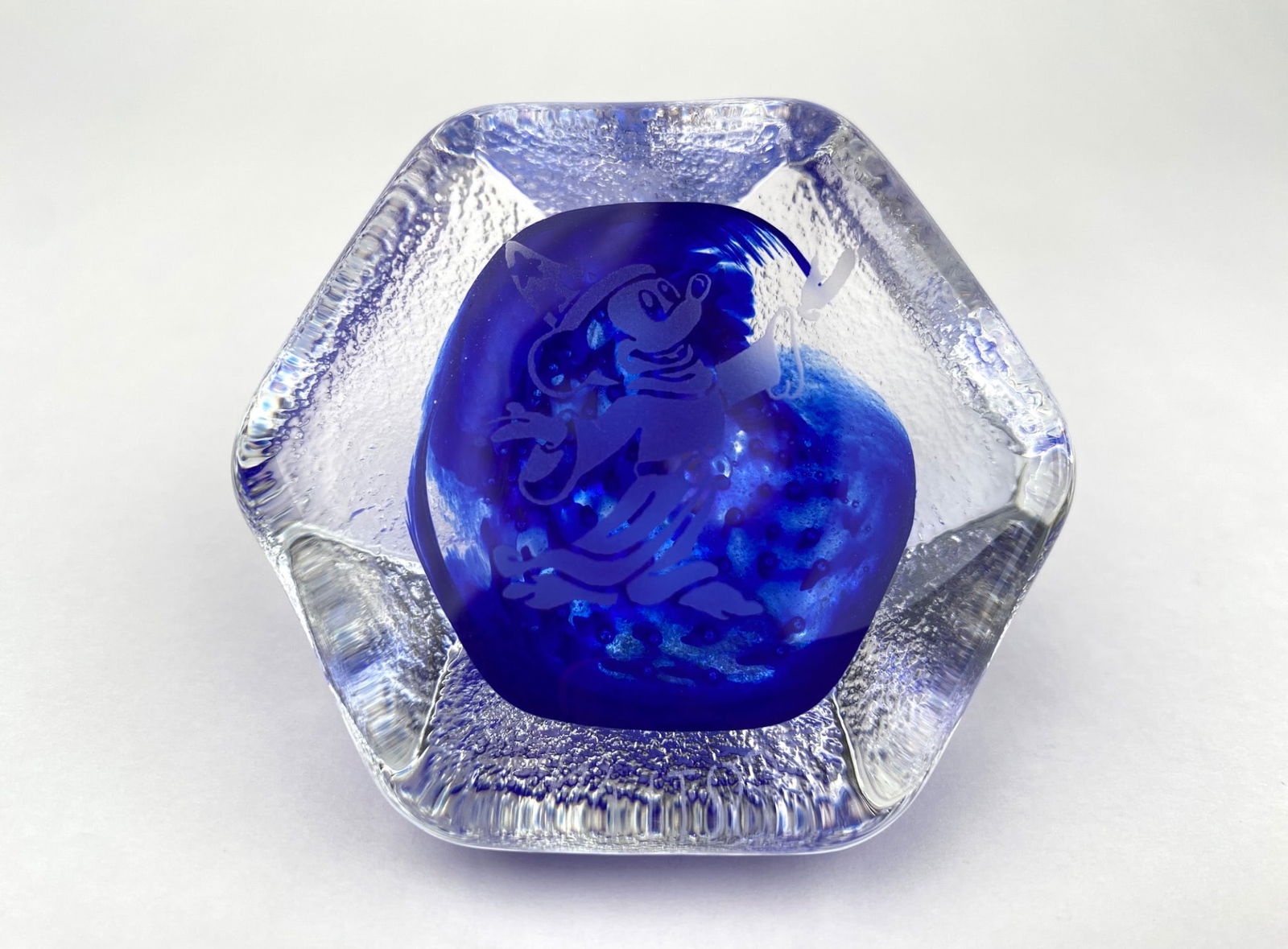 Caithness Glass Sorcerer Mickey Paperweight from Scotland: Disney glass paperweight featuring an etched depiction of Sorcerer Mickey in a hexagonal design with vibrant cobalt blue hues. Crafted in Scotland, as indicated on the base. The piece also includes a