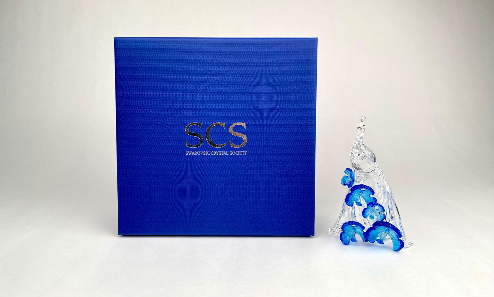 Swarovski Crystal Society (SCS) White Peacock Figurine with Box: Swarovski Crystal Society (SCS) white peacock figurine featuring intricate clear and blue crystal accents. The peacock showcases a highly detailed design with a clear faceted body and vibrant blue dec