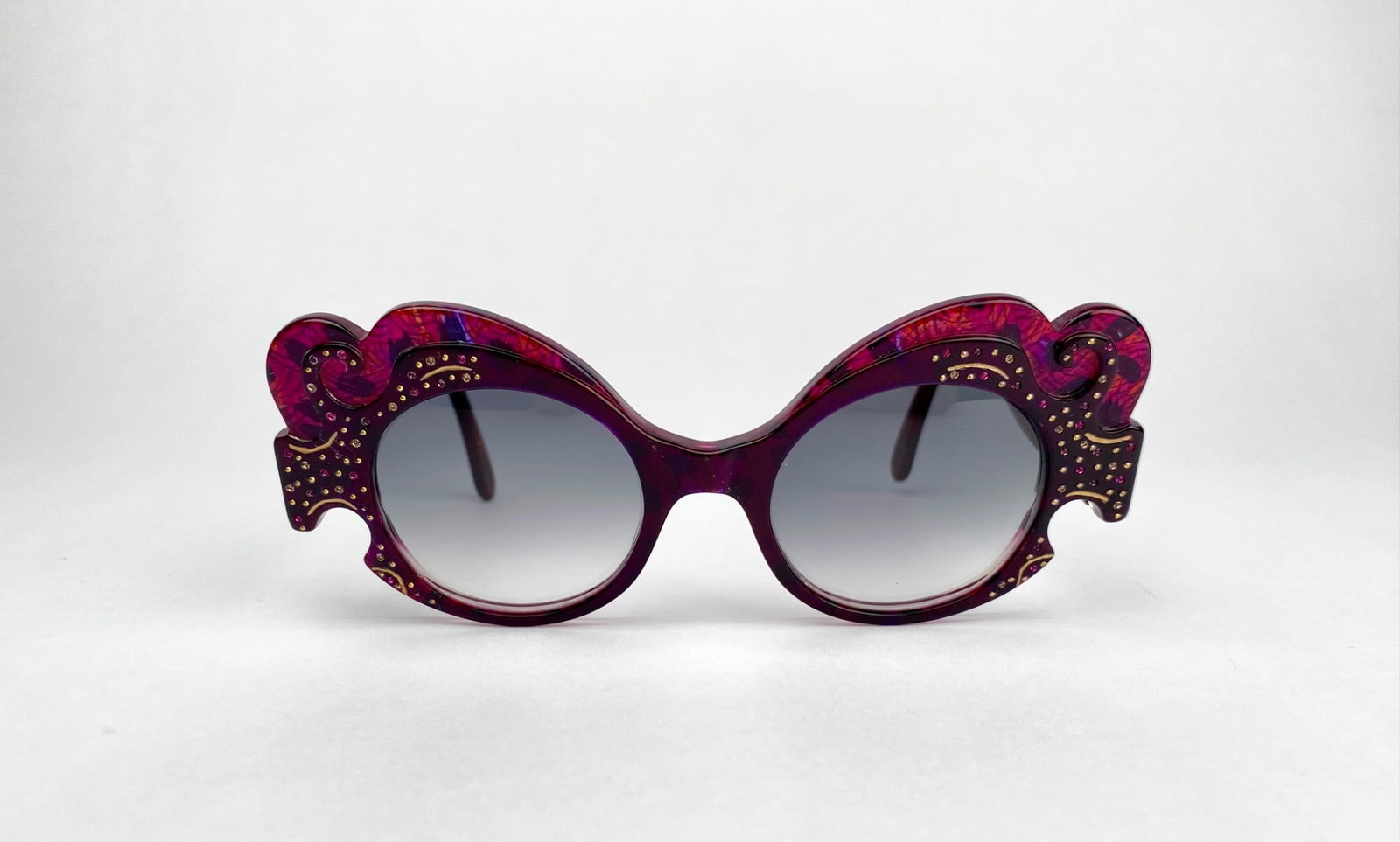 Francis Klein “Wouri" Purple Ornate Sunglasses: Francis Klein oversized sunglasses featuring intricate design details on the frames, accented with golden embellishments. The interior arms are marked “Francis Klein” in script and “WOURI C4