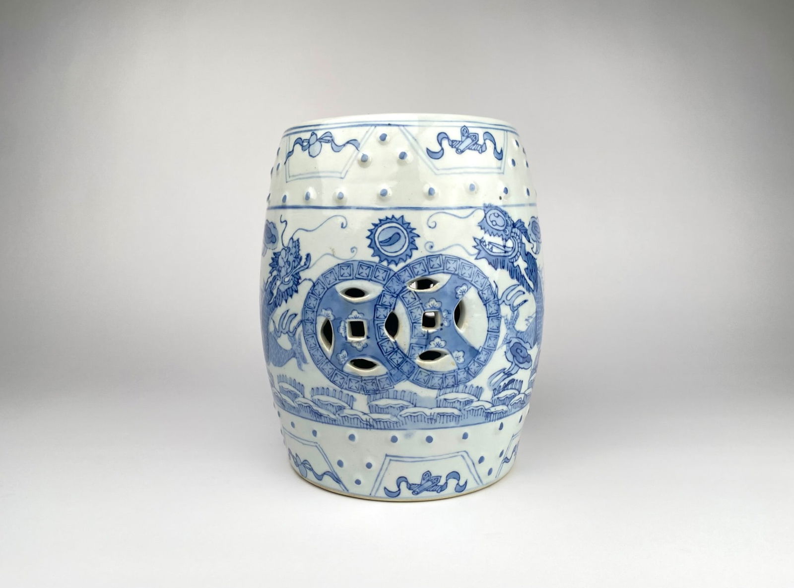Chinese Blue & White Porcelain Garden Stool with Dragon & Coin Motif: Chinese blue and white porcelain garden stool featuring dragon and coin motif. The surface is adorned with studs and accented by intricate detailing. Wear and slight imperfections are present. | Pleas
