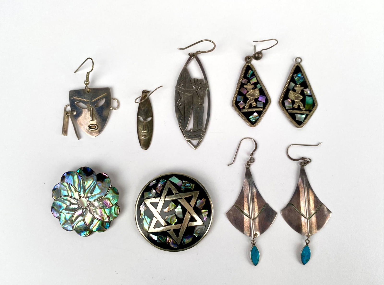 Lot of Sterling Silver & Abalone Jewelry (Brooches & Earrings): Sterling silver jewelry, featuring various items including earrings and brooches. The earrings include a pair with blue stone drops, mask-shaped pieces, and inlayed abalone designs showcasing whimsica