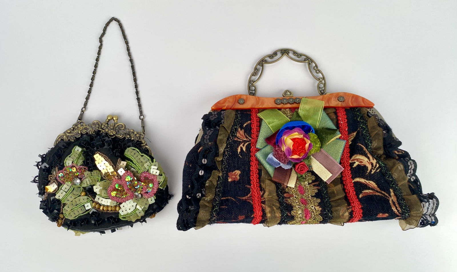 Pair of Embellished Handbags with Floral Detailing & Metal Handles: Vibrant embellished handbags featuring floral motifs, detailed metallic handles, and ornate designs. Larger handbag includes a rigid metal handle, fabric lining with gold accents, fringed details, and
