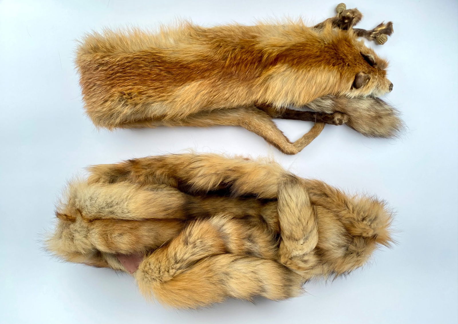 Pair of Vintage Fox Fur Stoles: Pair of fox fur stoles featuring natural fur pelts. One stole includes a satin-lined interior with visible fabric details. Items show wear commensurate with age and use, including fur matting and wear