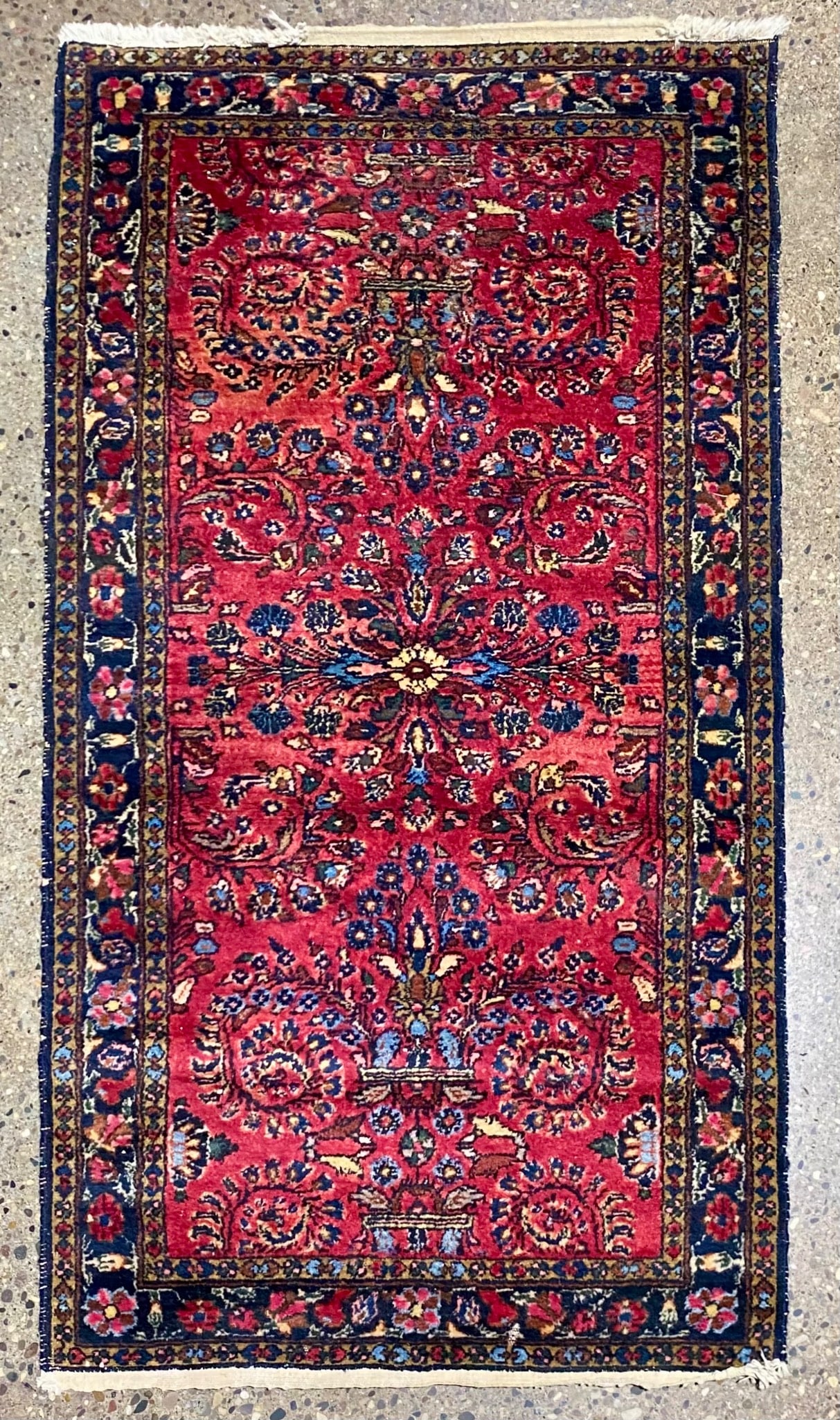 Vintage Hand-Knotted Persian Floral Rug: Hand-knotted Persian wool rug featuring an intricate floral design with a red field and contrasting navy border. The rug displays detailed motifs in a variety of rich colors, characteristic of Persian
