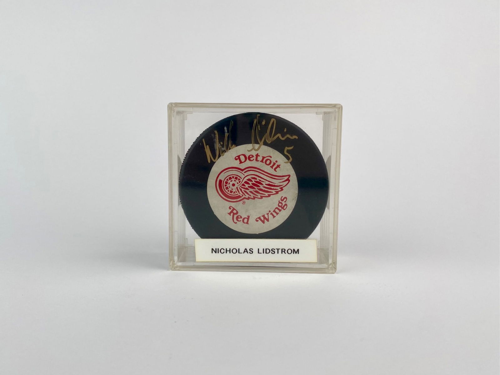 Nicklas Lidstrom Signed Detroit Red Wings Souvenir Hockey Puck: Detroit Red Wings NHL souvenir hockey puck signed in gold ink by Hall of Fame defenseman Nicklas Lidstrom, who played his entire career on the Red Wings and wore jersey number #5. The signature appear