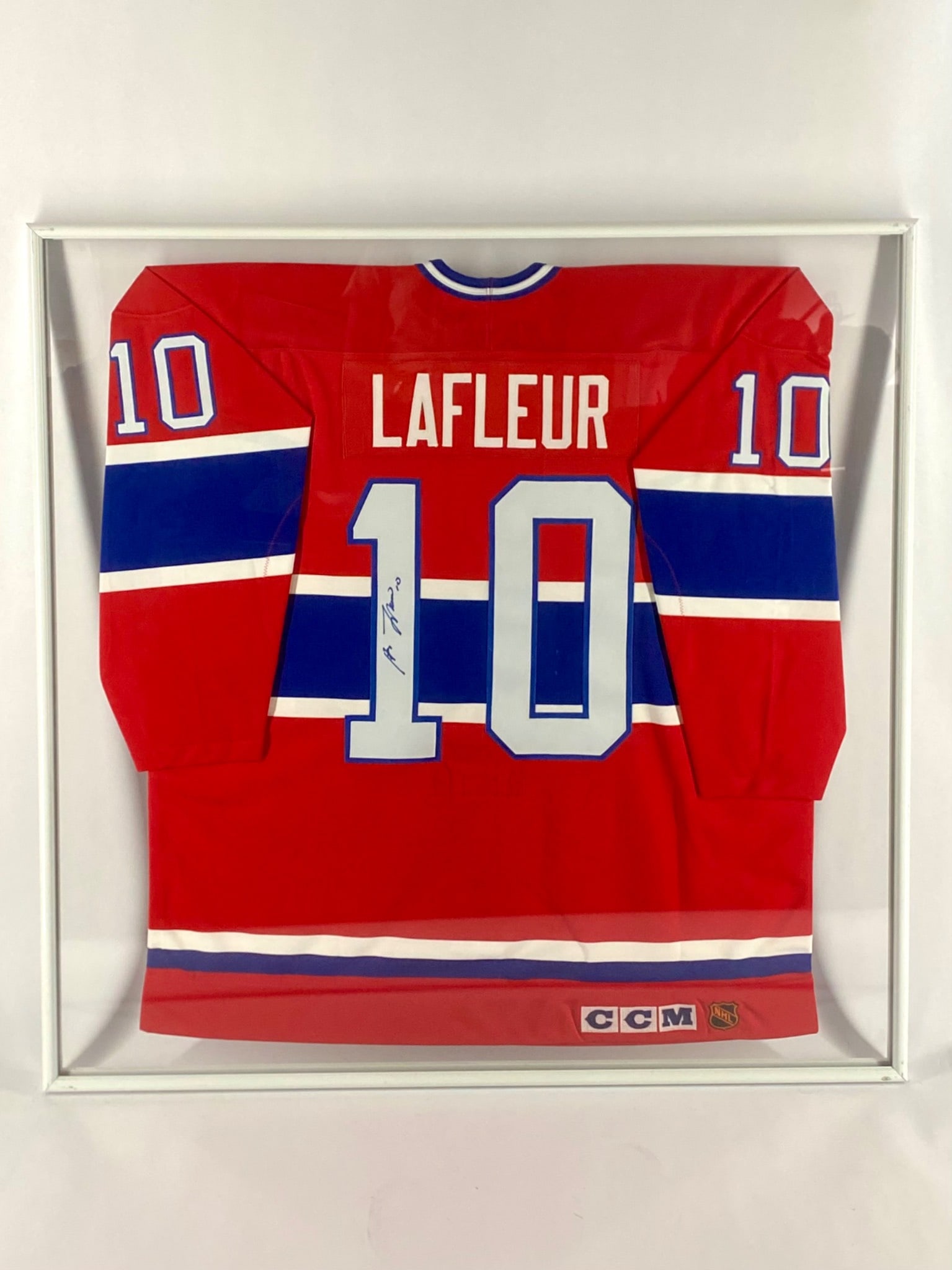Guy Lafleur Signed Montreal Canadiens Framed Jersey: Framed Montreal Canadiens jersey signed by Hall of Famer Guy Lafleur. The CCM jersey features Lafleur’s number 10 on the back, with his autograph in blue ink inscribed vertically on the numeral. Dis