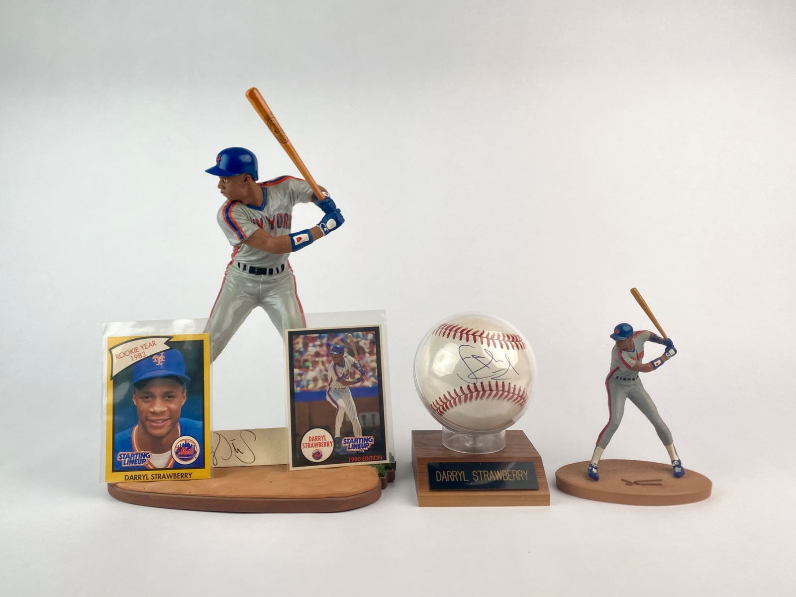 Darryl Strawberry Signed Memorabilia Set: Five-piece Darryl Strawberry memorabilia set including a Gartlan USA hand-painted figurine titled “Strawman,” numbered 2032/2500 and mounted on a wood-style strawberry shaped base featuring an