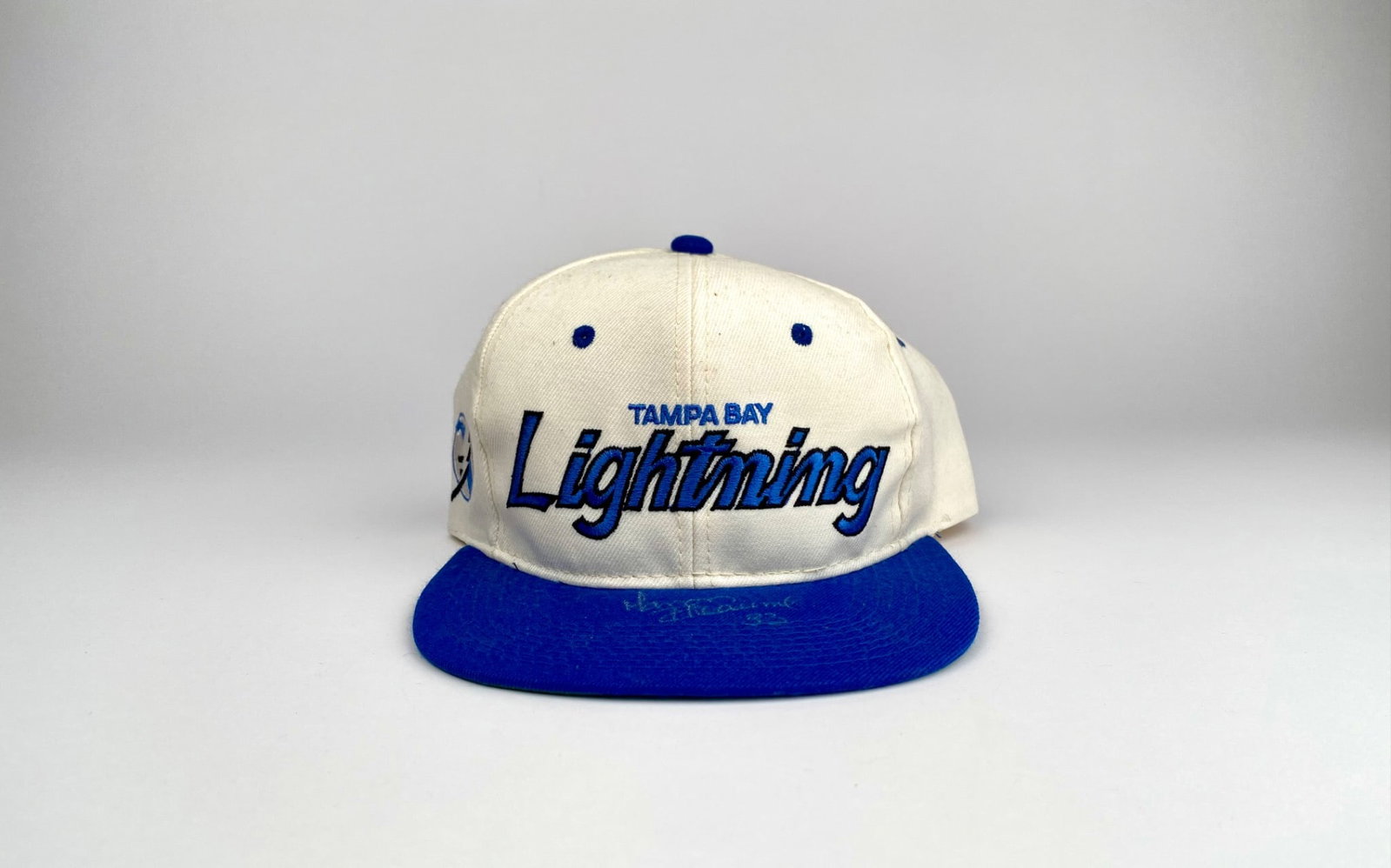 Tampa Bay Lightning Hat Signed by Manon Rheaume (#33): Tampa Bay Lightning snapback hat by Sports Specialties featuring the team name embroidered on the front and the team logo on the side. Signed on the blue brim by Manon Rheaume. Interior tags read “A