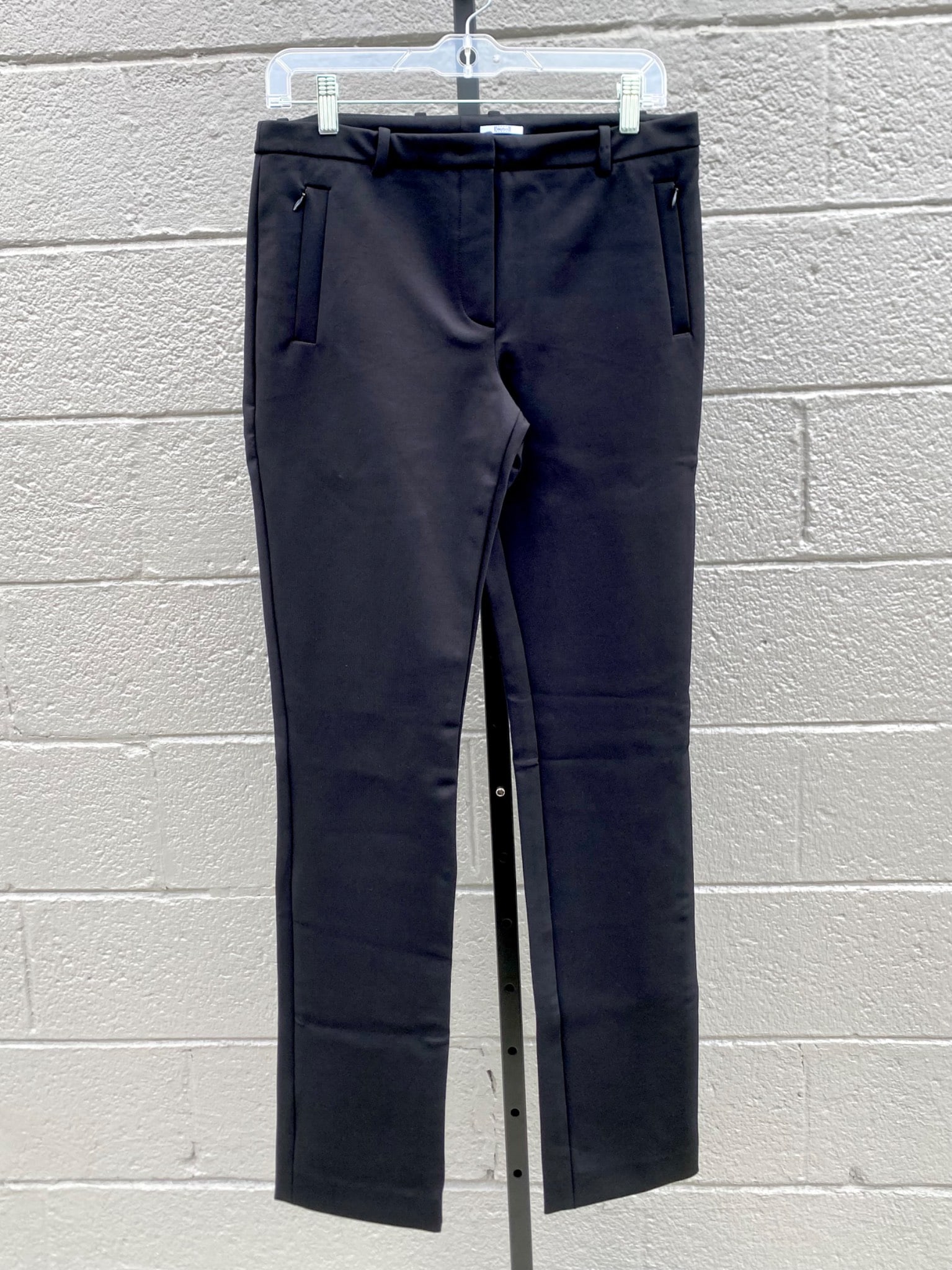 Wolford Black Tailored Slim Fit Stretch Trousers, Size 38: Pair of black slim fit trousers by Wolford, crafted from a stretch fabric blend of polyamide and elastane. The trousers feature a sleek modern silhouette with zippered front pockets, belt loops, and a