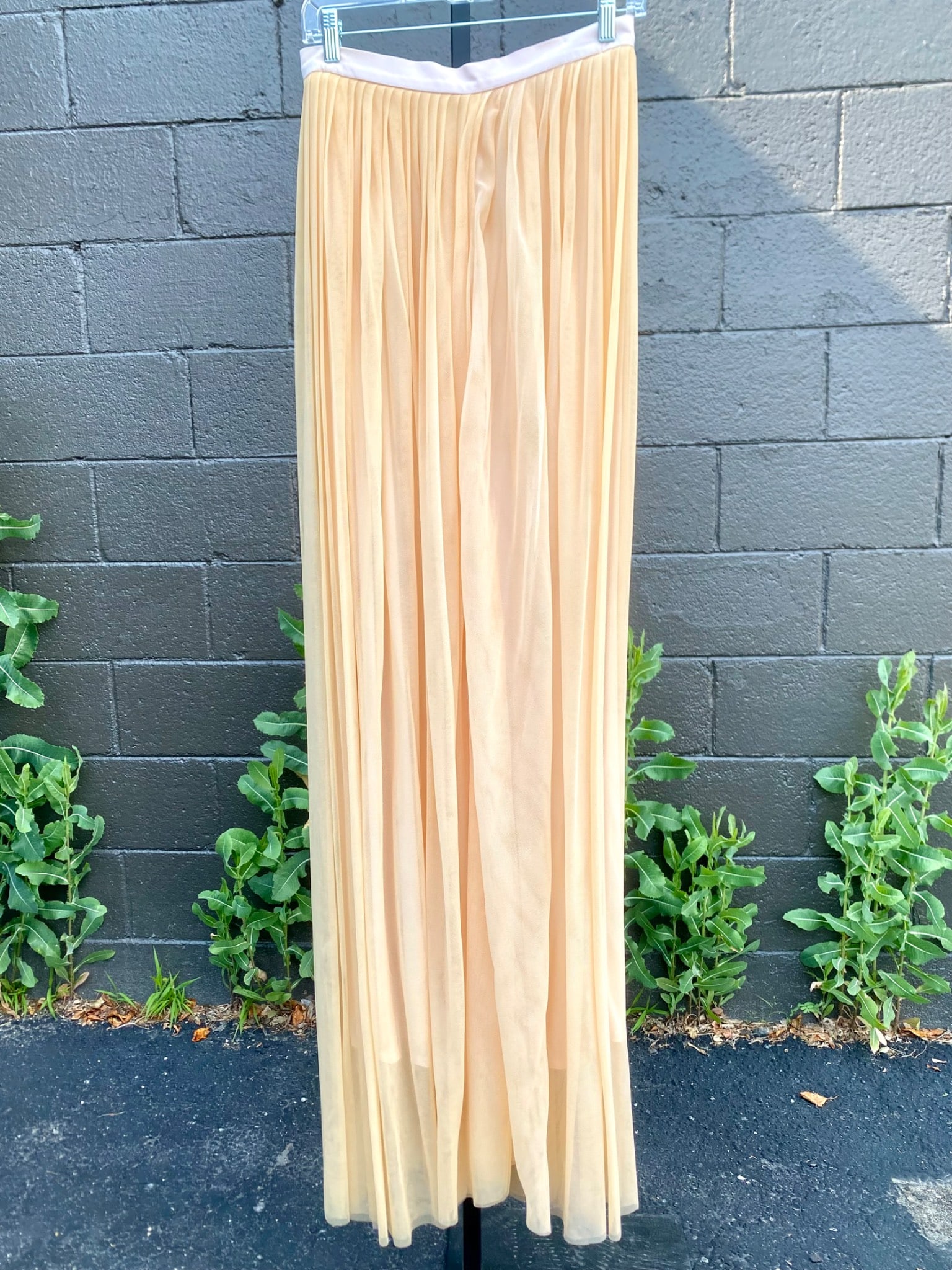 Mondi Pleated Peach Tulle Maxi Skirt, Size 38: Mondi pleated peach colored maxi skirt featuring an airy tulle overlay and a silky full lining. The skirt is detailed with a soft satin waistband in a complementary shade and a rear button and zipper 