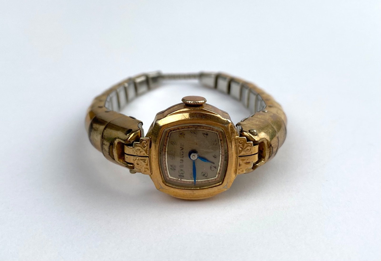 Vintage R.E.F. 10K Rolled Gold Plated Ladies Wristwatch (Swiss Made): Women’s wristwatch featuring a gold-plated rectangular case with blue hour and minute hands on a face with hour markers. The watch case back is inscribed with “R.E.F.” and marked “10K Roll