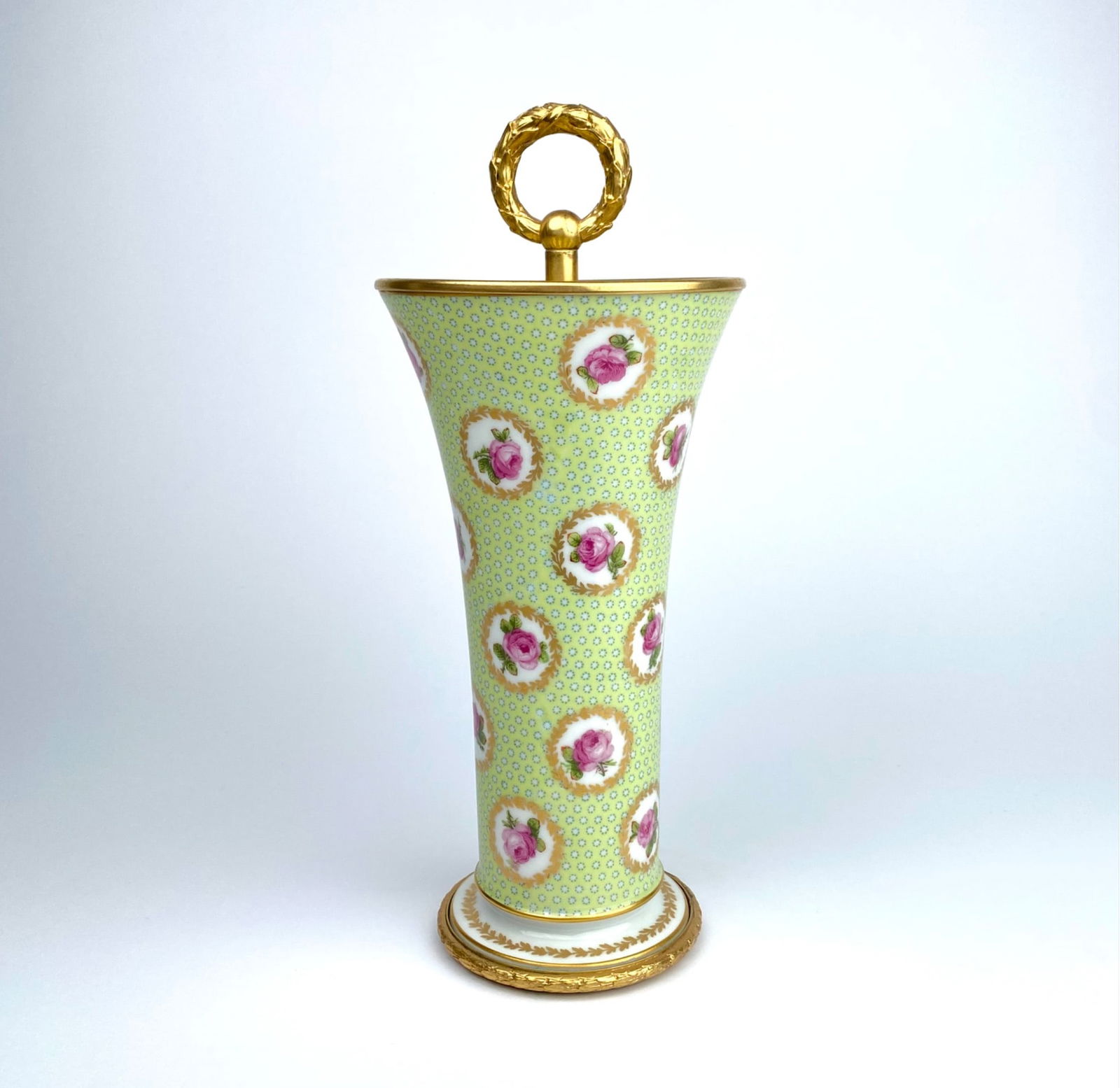German Porcelain Spill Vase with Gilt Brass Mounts, Baden-Baden, Cira 1850: German-made hand-painted porcelain spill vase with an intricate floral pattern, featuring pink roses surrounded by small daisy motifs on a pale green background. The vase is accented with brass gilt d